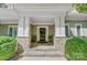 Elegant entrance featuring stone columns and a dark wood door, surrounded by lush green shrubbery at 3508 Mountain Cove Dr, Charlotte, NC 28216