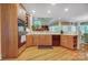 Well-equipped kitchen with wood cabinetry, built-in appliances, and a view into an adjacent living area at 3508 Mountain Cove Dr, Charlotte, NC 28216