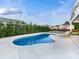 Beautiful backyard featuring a sparkling pool, a cozy patio and lounge chairs, all surrounded by lush greenery at 405 Winding Oaks Se Ln, Concord, NC 28025