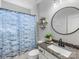 Well-lit bathroom with a patterned shower curtain, and a granite vanity for a clean, comfortable space at 405 Winding Oaks Se Ln, Concord, NC 28025
