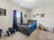 Inviting bedroom featuring a gray bed with blue bedding, carpeting and neutral walls, creating a peaceful retreat at 405 Winding Oaks Se Ln, Concord, NC 28025