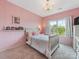 Charming bedroom featuring pink patterned wallpaper, a chandelier, and plenty of natural light, creating a whimsical space at 405 Winding Oaks Se Ln, Concord, NC 28025