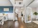 Spacious foyer featuring hardwood floors, a staircase, and an adjacent dining area with stylish decor at 405 Winding Oaks Se Ln, Concord, NC 28025