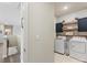 Well-organized laundry area with modern machines, cabinets, shelving, and stylish decor at 405 Winding Oaks Se Ln, Concord, NC 28025