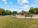 A playground with benches, swing set, and play structure set within green space at 405 Winding Oaks Se Ln, Concord, NC 28025