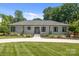 Charming single-story home with light grey brick, manicured lawn and inviting walkway to the front door at 4147 Chelmsford Rd, Charlotte, NC 28211