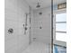 Beautiful tiled shower featuring a rain shower head and a built-in toiletry shelf at 4147 Chelmsford Rd, Charlotte, NC 28211
