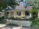 This property features a charming yellow exterior, enhanced by a white picket fence and lush landscaping at 500 W Council St, Salisbury, NC 28144