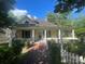 Charming yellow two-story home with a brick walkway and covered porch, showcasing curb appeal and a welcoming entrance at 500 W Council St, Salisbury, NC 28144