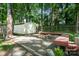 Serene backyard featuring a fire pit, wooden benches, and a storage shed, ideal for outdoor relaxation at 7357 Elwood Dr, Charlotte, NC 28227