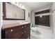 Well-maintained bathroom with an antique vanity, decorative mirror, and tiled shower-tub combination at 7357 Elwood Dr, Charlotte, NC 28227