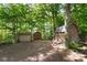 Backyard features three rustic outbuildings surrounded by mature trees at 7525 Cedarbrook Dr, Charlotte, NC 28215