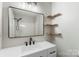 Updated bathroom with a large mirror, white vanity and modern matte black fixtures at 7525 Cedarbrook Dr, Charlotte, NC 28215