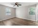 Well-lit bedroom features two windows, ceiling fan and wood-look flooring at 7525 Cedarbrook Dr, Charlotte, NC 28215