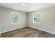 Bright and airy bedroom with wood-look flooring and windows at 7525 Cedarbrook Dr, Charlotte, NC 28215