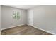 Cozy bedroom with a large window and wood-look flooring at 7525 Cedarbrook Dr, Charlotte, NC 28215