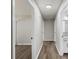 Clean hallway with wood-look flooring connecting multiple rooms and a bathroom at 7525 Cedarbrook Dr, Charlotte, NC 28215
