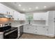 A well lit kitchen featuring white cabinets and stainless steel appliances at 7525 Cedarbrook Dr, Charlotte, NC 28215