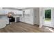 Bright kitchen features white cabinets, stainless steel appliances, and wood-look flooring at 7525 Cedarbrook Dr, Charlotte, NC 28215