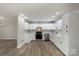 Modern kitchen with white cabinets, stainless steel appliances, and updated floors at 7525 Cedarbrook Dr, Charlotte, NC 28215
