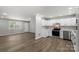Open-concept living room and kitchen area with natural light and wood-look flooring at 7525 Cedarbrook Dr, Charlotte, NC 28215
