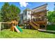 Expansive backyard with a large deck, playset, and mature trees at 7722 Garnkirk Dr, Huntersville, NC 28078