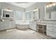 Bright bathroom features a soaking tub with tile surround and dual vanity sinks at 7722 Garnkirk Dr, Huntersville, NC 28078