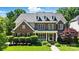 Charming brick two-story home featuring a well-manicured lawn and a welcoming front porch at 7722 Garnkirk Dr, Huntersville, NC 28078