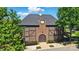 Detailed brick building exterior with a unique clock tower feature and manicured landscaping at 7722 Garnkirk Dr, Huntersville, NC 28078
