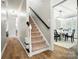 Welcoming hallway leads to dining room, featuring wood floors and carpeted stairs at 7722 Garnkirk Dr, Huntersville, NC 28078