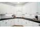 Kitchen featuring white cabinets, modern appliances, black countertops, and ample space for cooking at 7722 Garnkirk Dr, Huntersville, NC 28078