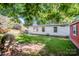 Backyard view showcases a home, storage building, and natural rock feature among trees at 7733 Skyline Dr, Sherrills Ford, NC 28673