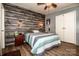 Cozy bedroom featuring wood accent wall, ceiling fan and unique decor at 7733 Skyline Dr, Sherrills Ford, NC 28673