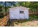 Exterior view of a small shed with a single window and door, nestled in a wooded area at 7733 Skyline Dr, Sherrills Ford, NC 28673
