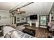 Inviting living room featuring wood-look floors, a brick fireplace, and a comfortable gray couch with natural light at 7733 Skyline Dr, Sherrills Ford, NC 28673