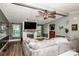 Spacious living room featuring a decorative fireplace, ceiling fan, wood-look flooring, and ample natural light at 7733 Skyline Dr, Sherrills Ford, NC 28673