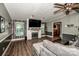 Living room features wood-look flooring, a brick fireplace with mounted TV, ceiling fan, and comfortable seating at 7733 Skyline Dr, Sherrills Ford, NC 28673