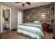 Comfortable bedroom with wood paneling accent wall, wood flooring and an attached bathroom at 7733 Skyline Dr, Sherrills Ford, NC 28673