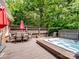 Backyard deck featuring a hot tub, outdoor furniture, and wooded backdrop at 8128 Sealey Ct, Charlotte, NC 28277
