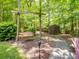 Tranquil backyard featuring a swing, storage shed, and lush greenery, perfect for relaxation at 8128 Sealey Ct, Charlotte, NC 28277