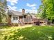 Expansive backyard showcasing a deck, screened porch, and lush lawn, perfect for outdoor enjoyment at 8128 Sealey Ct, Charlotte, NC 28277