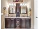 Primary bathroom featuring double sinks, granite countertop, and dark wood cabinetry at 8128 Sealey Ct, Charlotte, NC 28277