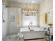Modern bathroom features a glass shower, separate soaking tub, and bright natural light at 8128 Sealey Ct, Charlotte, NC 28277