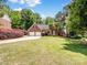 Traditional brick home with a well-manicured lawn, mature trees, and a two-car garage at 8128 Sealey Ct, Charlotte, NC 28277