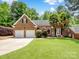 Charming brick home with a lush front lawn, two car garage, and inviting curb appeal at 8128 Sealey Ct, Charlotte, NC 28277