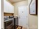 Laundry room with front load washer and dryer plus white storage cabinets at 8128 Sealey Ct, Charlotte, NC 28277