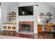 Cozy fireplace with brick surround, custom shelves, and a built-in desk at 8501 Flanagan Ct, Huntersville, NC 28078