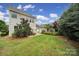 Large backyard with a patio featuring lounge seating and an umbrella, with a detached garage at 8702 Aspinwall Dr, Charlotte, NC 28216