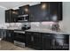 Well-equipped kitchen with dark cabinets, stainless steel appliances, granite countertops and a stylish tile backsplash at 8702 Aspinwall Dr, Charlotte, NC 28216