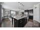 Modern kitchen featuring dark cabinets, stainless steel appliances, granite countertops and seating at the island at 8702 Aspinwall Dr, Charlotte, NC 28216
